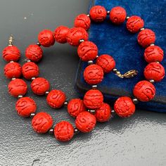 Vintage ~ Hand carved Chinese Cinnabar Beaded Necklace featuring are 1/2 inches in diameter beads which are deeply carved , with Floral /scroll patterns all around ~ Necklace ends with tongue and box clasp Measurements : Necklace measures 22 1/2 inches in length x 1/2 inches max width Condition : Good vintage condition ~ Very less surface ware ~ Most likely its restrung recently ~ Clasp is in good working order , but looks to be a replacement /later addition . Please Note ~ As vintage items are Traditional Carved Beaded Necklaces For Jewelry Making, Traditional Carved Round Beads Necklace, Traditional Necklace With Carved Round Beads, Antique Carved Round Necklace, Carved Round Beads Jewelry Gift, Traditional Round Carved Necklaces, Vintage Carved Round Beads Necklace, Traditional Red Carved Necklace, Vintage Carved Beaded Necklaces As Gifts