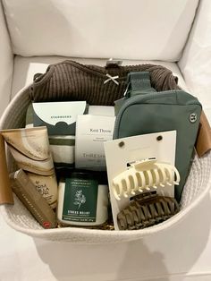 a basket filled with personal care items on top of a white couch next to a bag