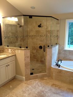 a bathroom with a walk in shower next to a bathtub and sink under a window