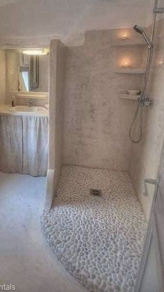 a bathroom with a shower, toilet and sink in it's corner area is shown