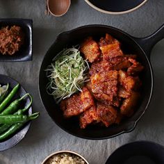 an overhead view of some food in a pan on a table with other dishes and utensils