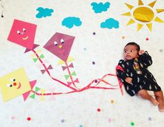 a baby is laying on the ground with kites