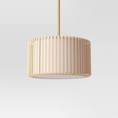 a white lamp hanging from a ceiling with a gold colored metal frame and pleated shade