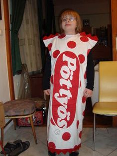 a woman in a polka dot costume standing next to a chair with a soda can on it's back