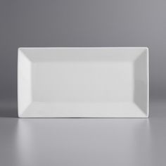 an empty white plate sitting on top of a table