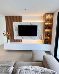 a living room with a couch, television and entertainment center in the middle of it