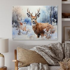 a painting of a deer in the snow on a wall above a couch with pillows