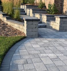 an outdoor patio with stone steps and planters on either side, surrounded by grass