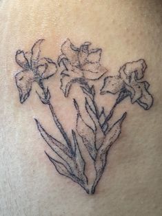 a close up of a person's stomach with flowers tattooed on the back of her chest