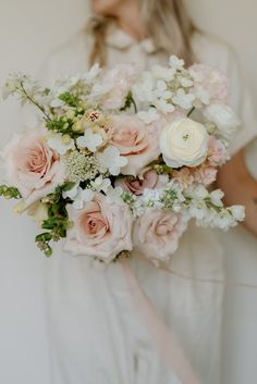 a woman holding a bouquet of flowers in her hands