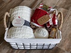 a white basket filled with christmas items on top of a wooden floor