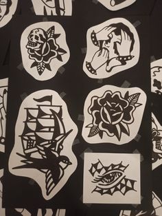 many different stickers on a black surface with white and black designs in the middle