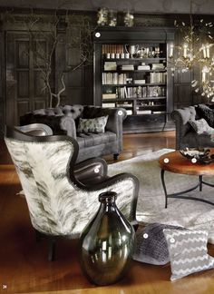 a living room filled with furniture and a book shelf full of books on top of it