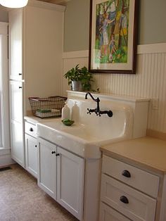 a white sink sitting under a window next to a mirror on a wall above it