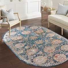 a living room with couches, chairs and an area rug on the hardwood floor