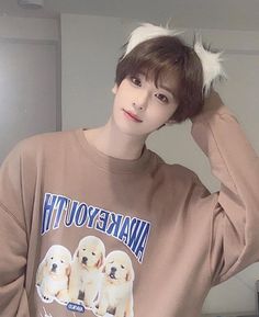 a young man wearing a brown sweatshirt with dogs on it's front and back