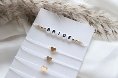 three pairs of gold heart studs on a card with the word bride written in cursive letters