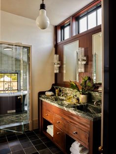 a bathroom with a sink, mirror and shower stall in the corner next to it