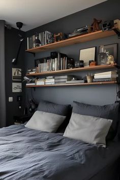 a bed with two shelves above it and some books on the top of each shelf