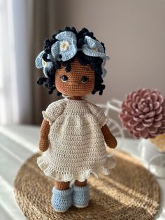 a crocheted doll is standing on a table