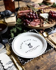 a table topped with plates and silverware next to a wooden table covered in food