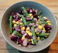 a bowl filled with green beans, corn and meat