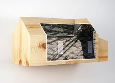 a house built into the side of a wooden wall with a window and roof on it