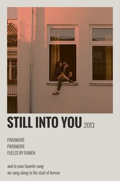 a person sitting on a window sill in front of a building with the words still into you 2013