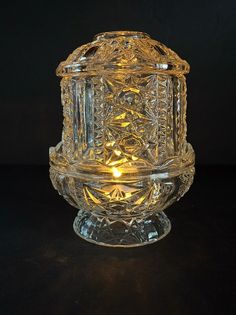 Add a touch of vintage charm to your home decor with this beautiful fairy lamp by Indiana Glass. The clear glass cylinder features a stunning stars and bars pattern that is sure to catch the eye of any admirer. Perfect for all occasions, this large lamp illuminates with a glossy finish and romantic theme. Crafted from high-quality glass materials, this fairy lamp is built to last and adds a unique touch to any room. The American style and decorative collectibles make it a great addition to any home. Get your hands on this one-of-a-kind piece today and add a touch of elegance to your living space. Fairy Lamps Vintage, Light Knight, Grandma Era, Lantern With Fairy Lights, Bars Design, Fairy Lamps, Thrift Ideas, Glass Fairy, Large Lamp