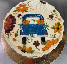 a decorated cake with an image of a truck and flowers on the front is shown