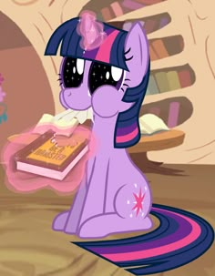 the pinkie is holding a birthday cake in her hand and looking at it's face