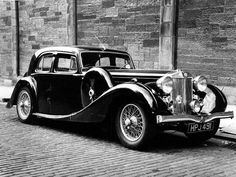 an old black and white photo of a dog sitting in the back of a car