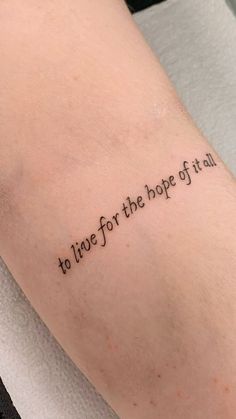 a tattoo saying to live for the hope of it all on someone's arm