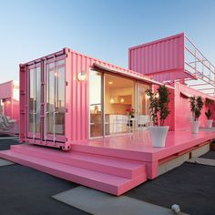 a pink house made out of shipping containers