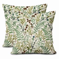 two pillows with green leaves and berries on them