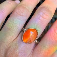 The incredible texture in this striped Rosecut Carnelian is truly one of a kind. Like a flowing river of orange lava it is set in 14k yellow gold with accent beads and a freeform sterling silver band. Approximate stone size: 14mm x 17mm 5.8 cts Mohs Stone Hardness: 6 This one of a kind piece is handmade to in Emily's Hudson Valley studio. This piece is in stock and can be resized prior to shipping. If you have questions about sizing, shipping or need help deciding please reach out to us! Unique Carnelian Ring Jewelry, Orange Fine Jewelry With Polished Finish, Oval Amber Agate Jewelry, 14k Gold Orange Jewelry With Polished Finish, Orange 14k Gold Jewelry With Polished Finish, Unique Carnelian Jewelry With Large Stone, Orange Polished Jewelry For Anniversary, Orange Fusion Jewelry Gift, Spiritual Carnelian Ring Jewelry