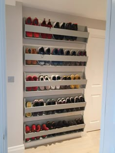 there are many pairs of shoes on the shelves in this room, all lined up