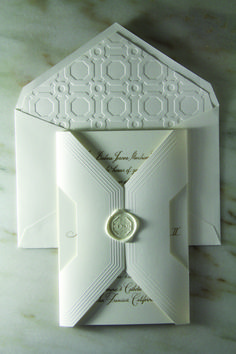 a white wedding card with an intricate design