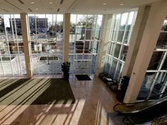 an empty room with lots of windows and wooden flooring on the side of it