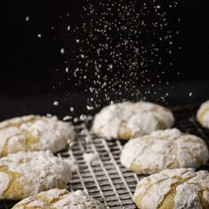 powdered sugar sprinkles are falling onto some cookies on a cooling rack