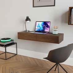 a laptop computer sitting on top of a wooden desk next to a record player and lamp