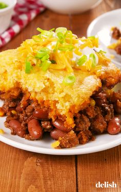 a close up of a plate of food with beans and cornbreads on it