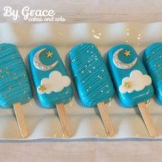 four popsicles decorated with blue icing and gold stars