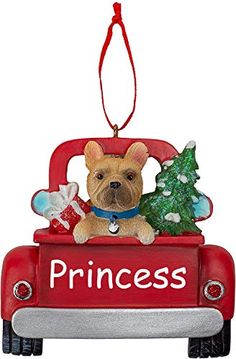 a christmas ornament with a dog in the back of a red pickup truck