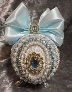 an ornament with a blue bow and some beads on it's side