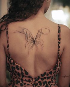 a woman with a butterfly tattoo on her back