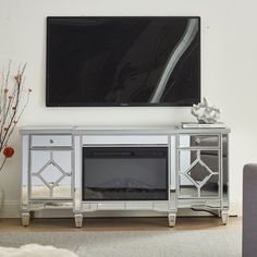 a living room with a large television mounted on the wall and a silver entertainment center