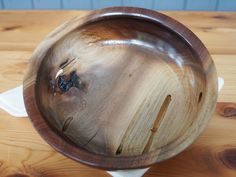 a wooden bowl sitting on top of a table