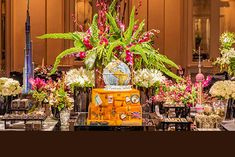 an arrangement of flowers in vases and other items on a table at a convention