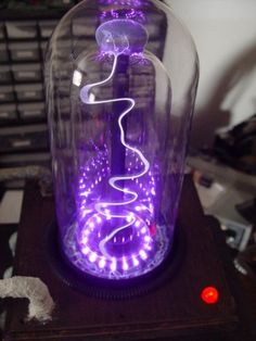 a purple light in a glass bottle on top of a table